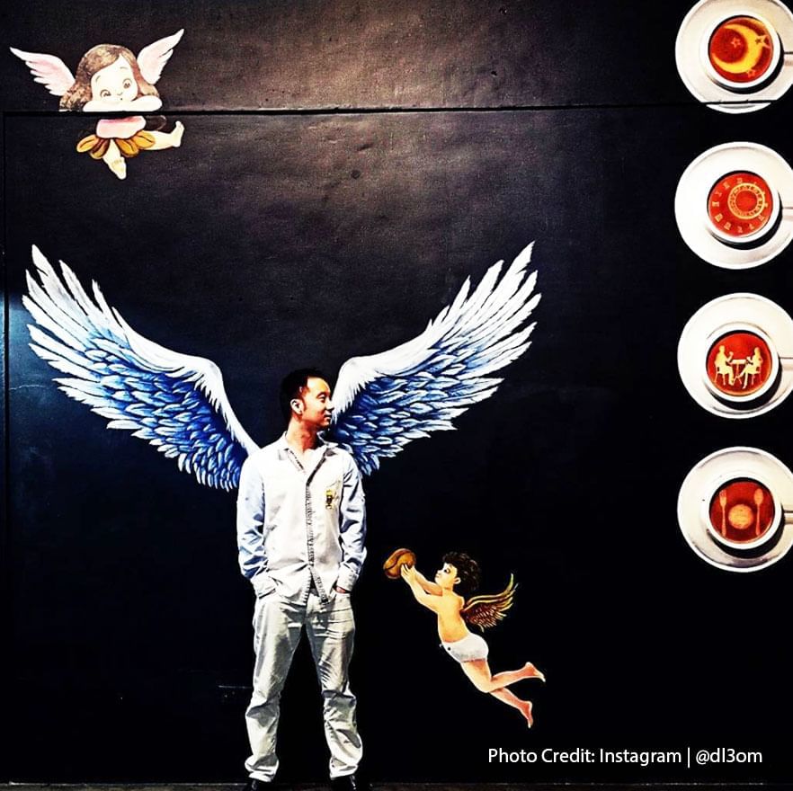 A man posing with mural paintings at Inns J Cafe, Port Dickson 