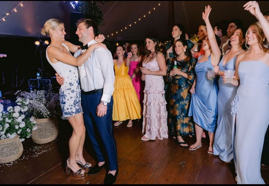 Group of people dancing at a wedding, with newlyweds in the center at The Clifton Hotel in Charlottesville, VA.