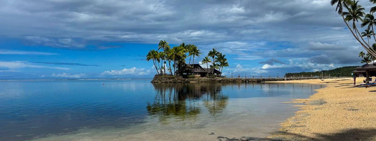 Sandy beach view with palm trees and ocean at Warwick Fiji Resort and Spa Korolevu