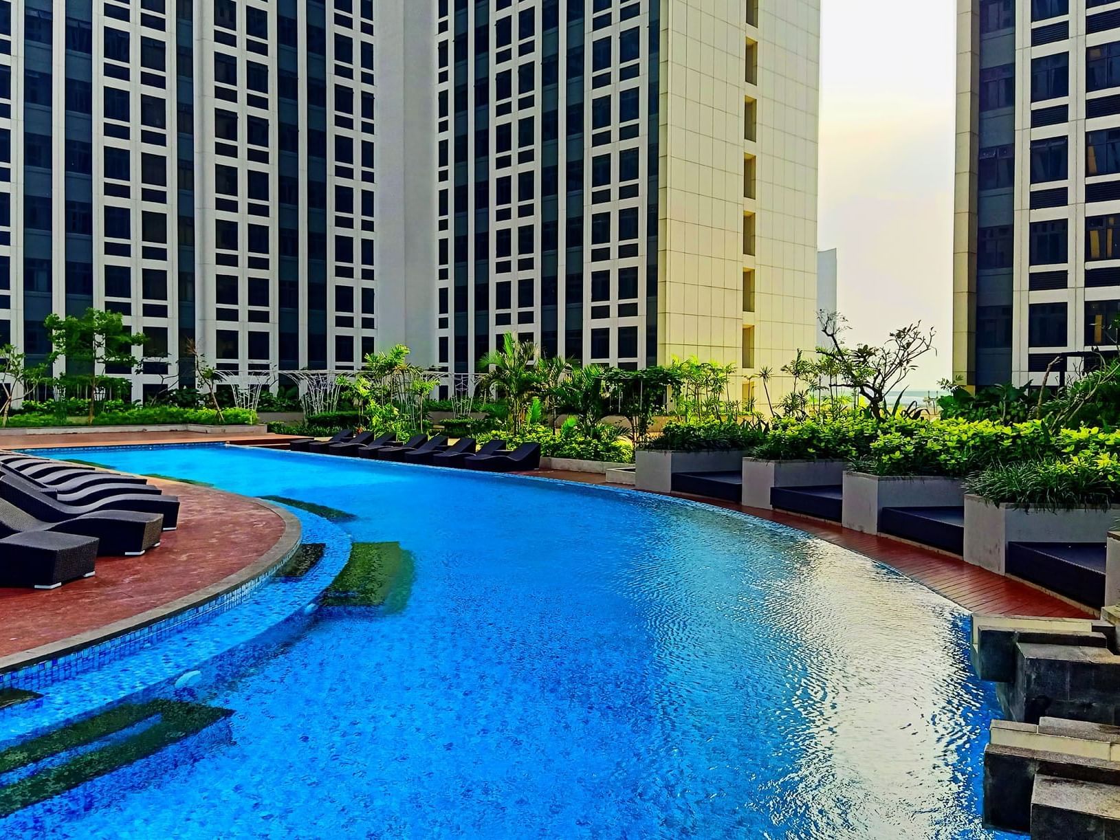 Outdoor swimming pool by the hotel buildings at LK Cikarang Hotel & Residences
