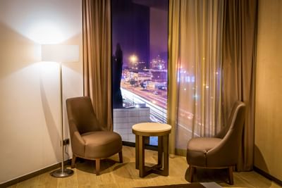 Sofas and coffee table next to a window with city views