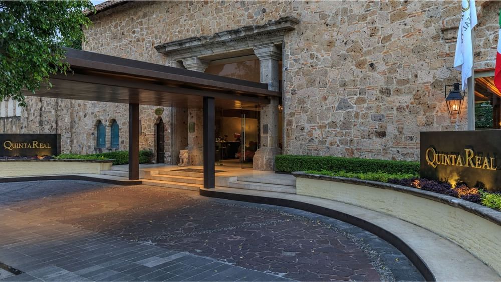 Gran arco de piedra y entrada cubierta con setos cuidados en Quinta Real Guadalajara