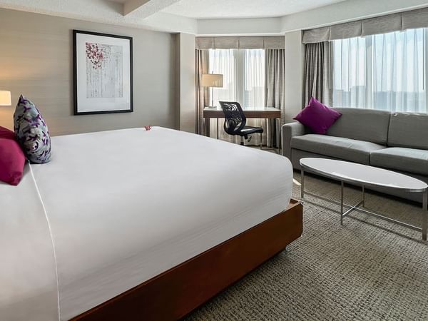 Hotel bedroom with bed, couch, and working desk