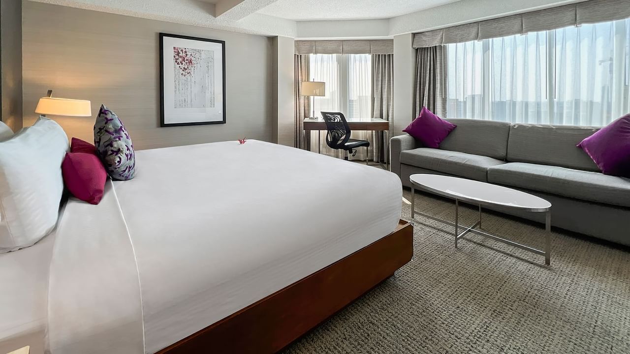 Hotel bedroom with bed, couch, and working desk