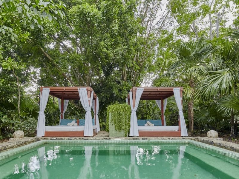 Outdoor pool with Two beds at The Explorean Cozumel