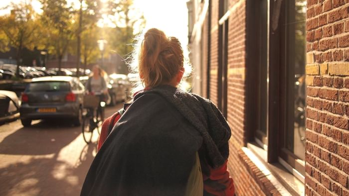 Back view of lady walking on a street near The Original Hotels