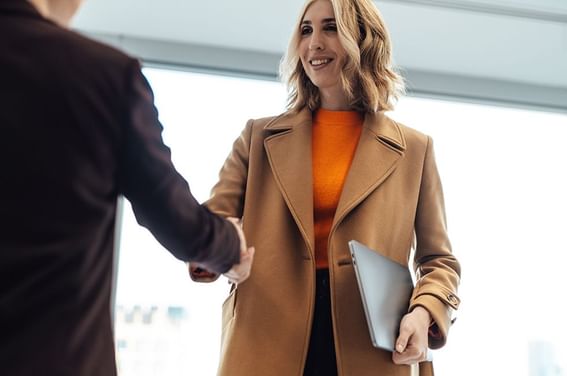 A business woman shaking hands with a business man