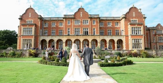 Back view of newlyweds posing at Easthampstead Park Hotel