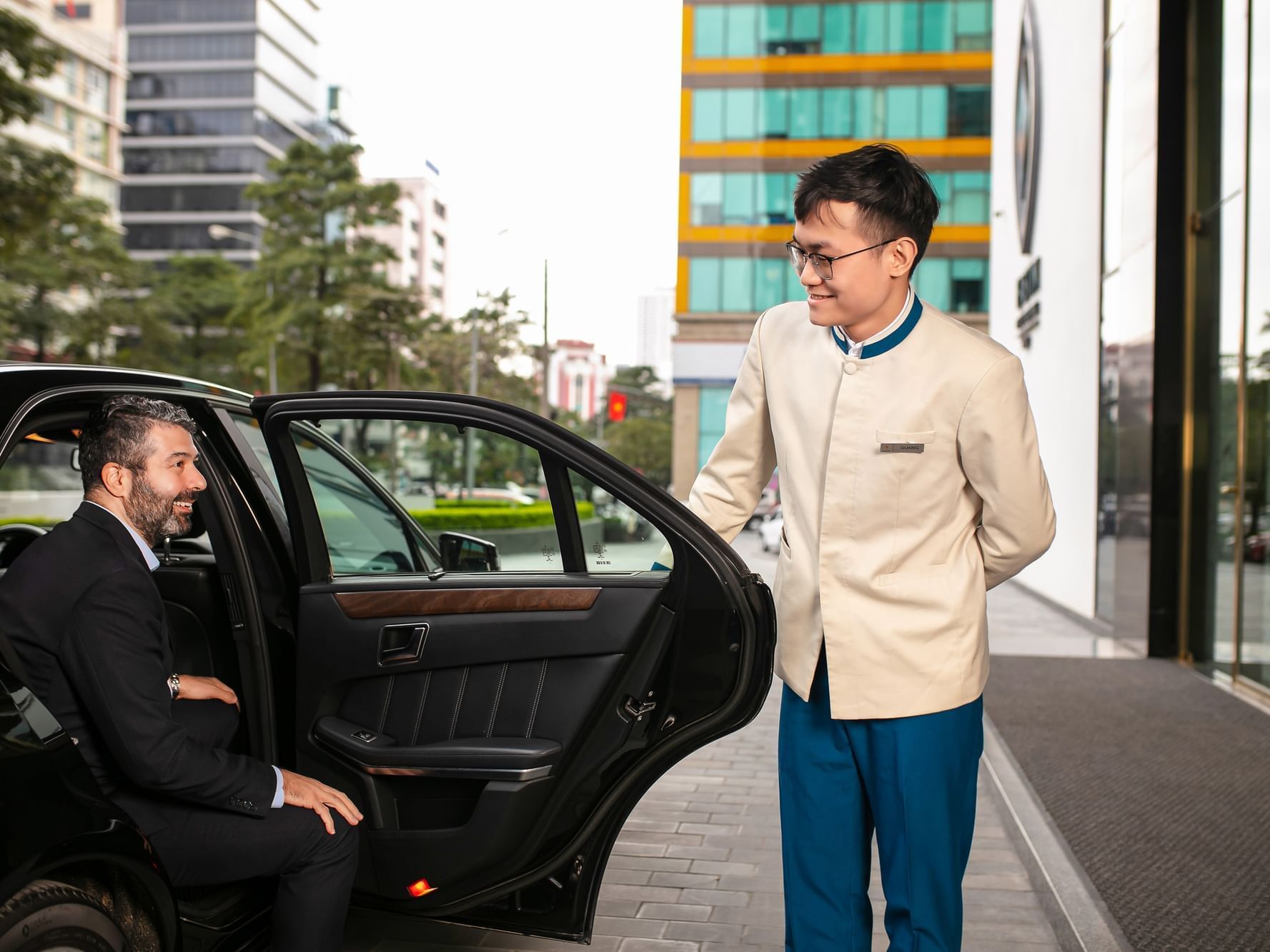 A chauffeur opening the car door at Eastin Hotels