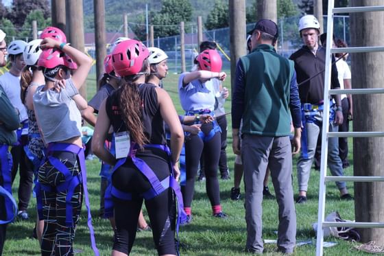People with harnesses and helmets at ropes course