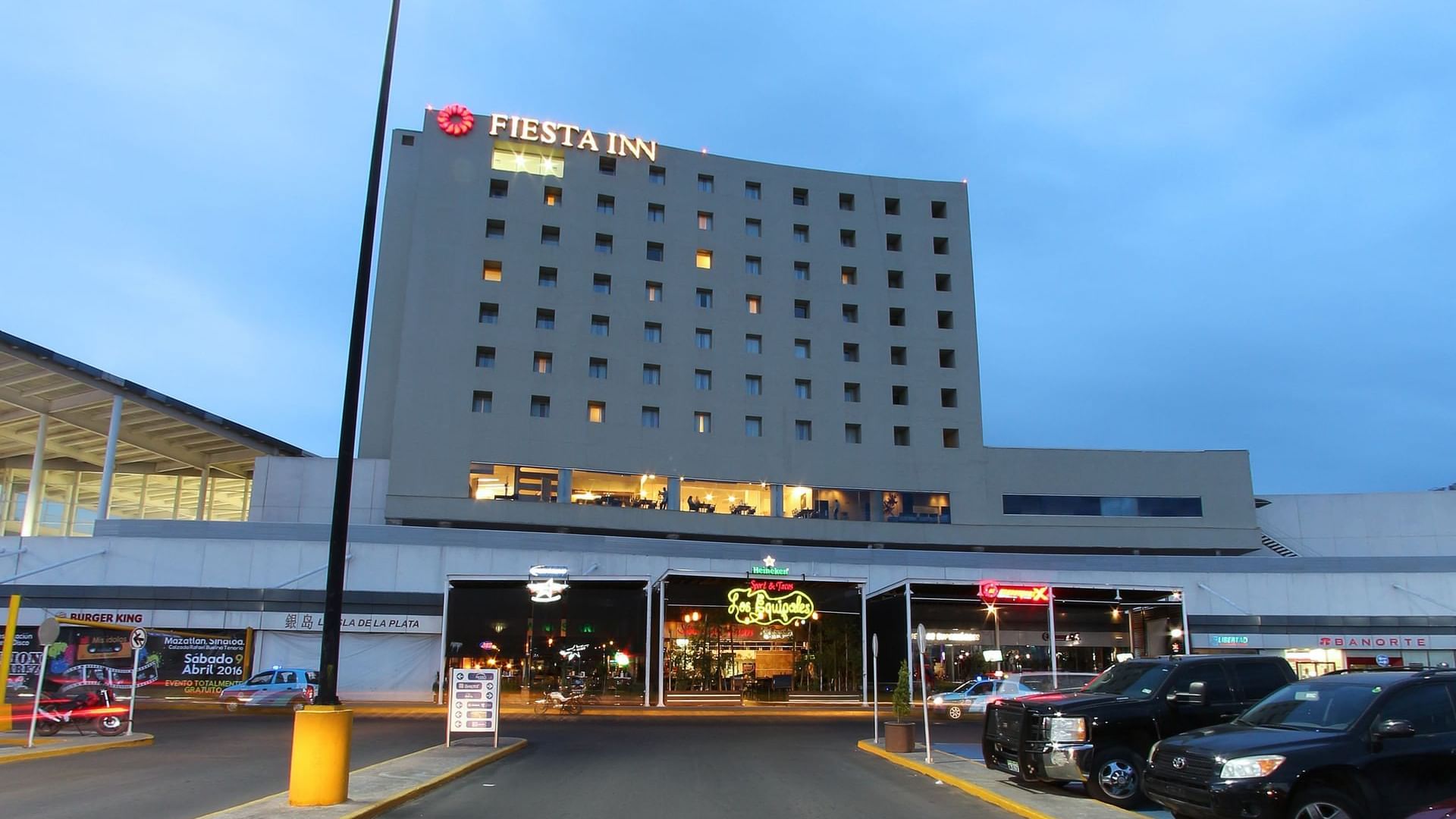 Evening exterior view with car park at Fiesta Inn Durango