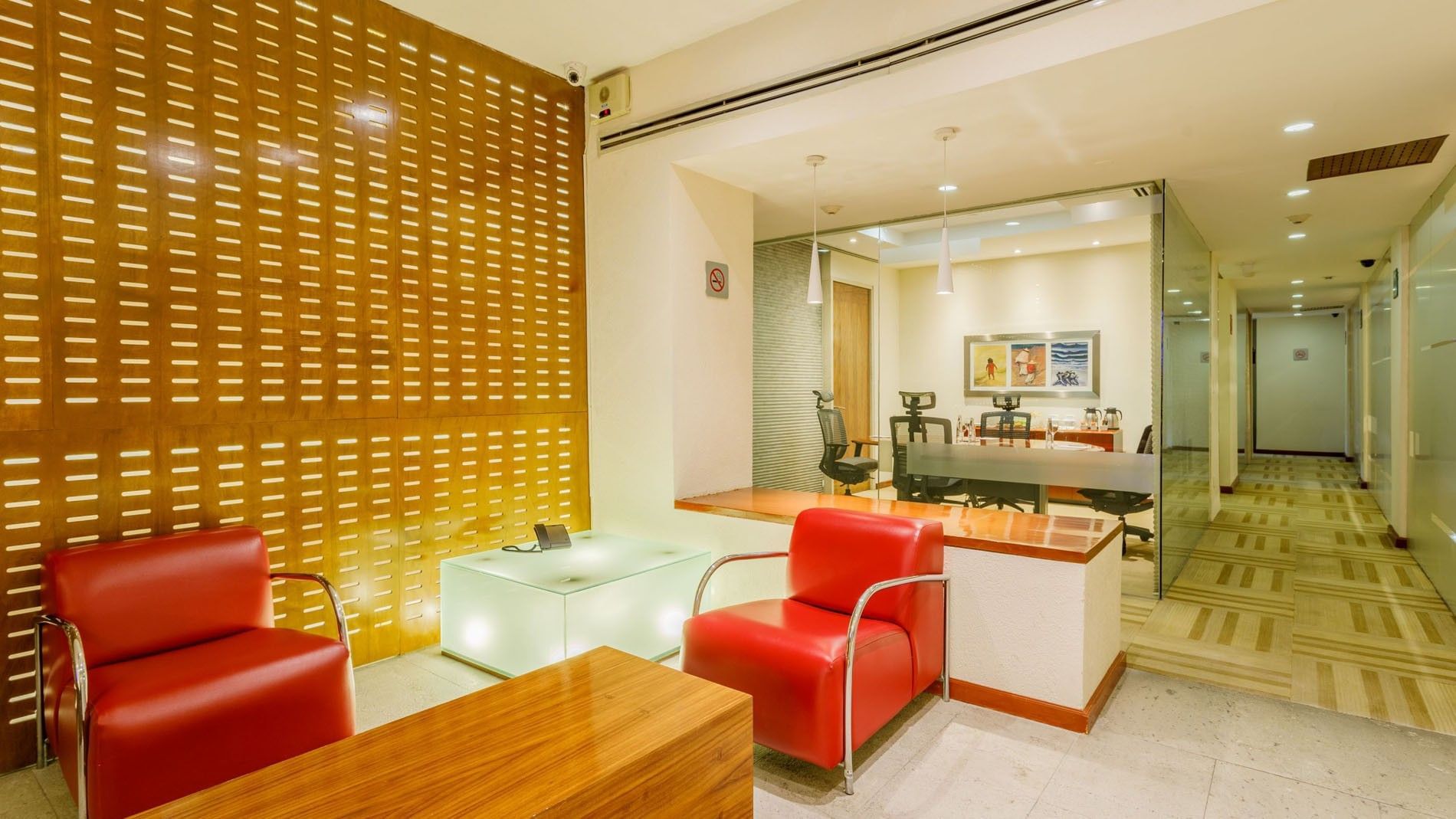 Modern office lounge featuring red leather armchairs by the wood slatted wall at Camino Real Aeropuerto Mexico