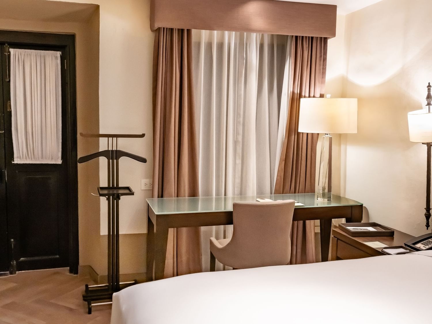 Habitación Novicia Matrimonial con cama king, escritorio y cortinas beige en Quinta Real Puebla