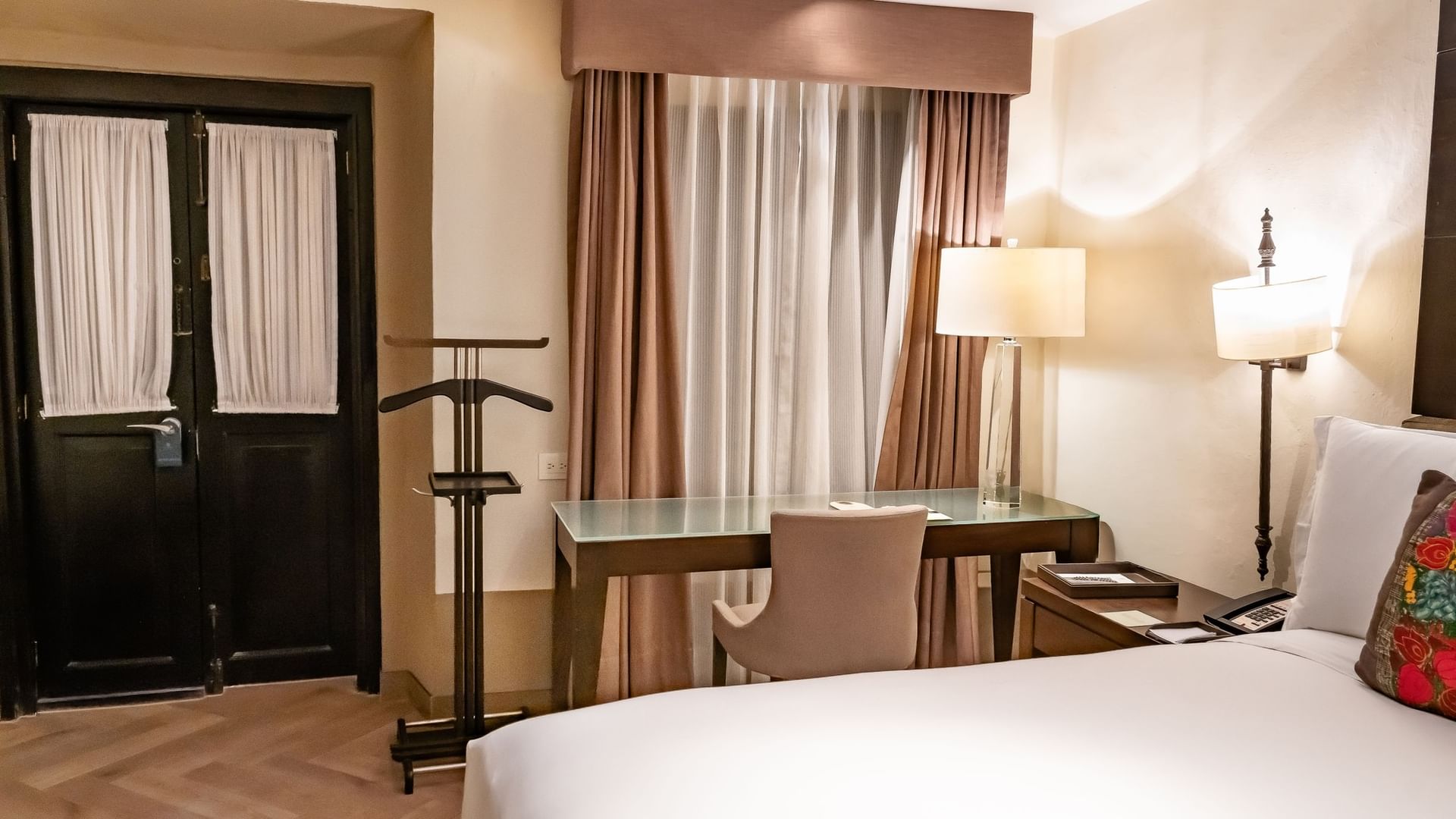 Habitación Novicia Matrimonial con cama king, escritorio y cortinas beige en Quinta Real Puebla