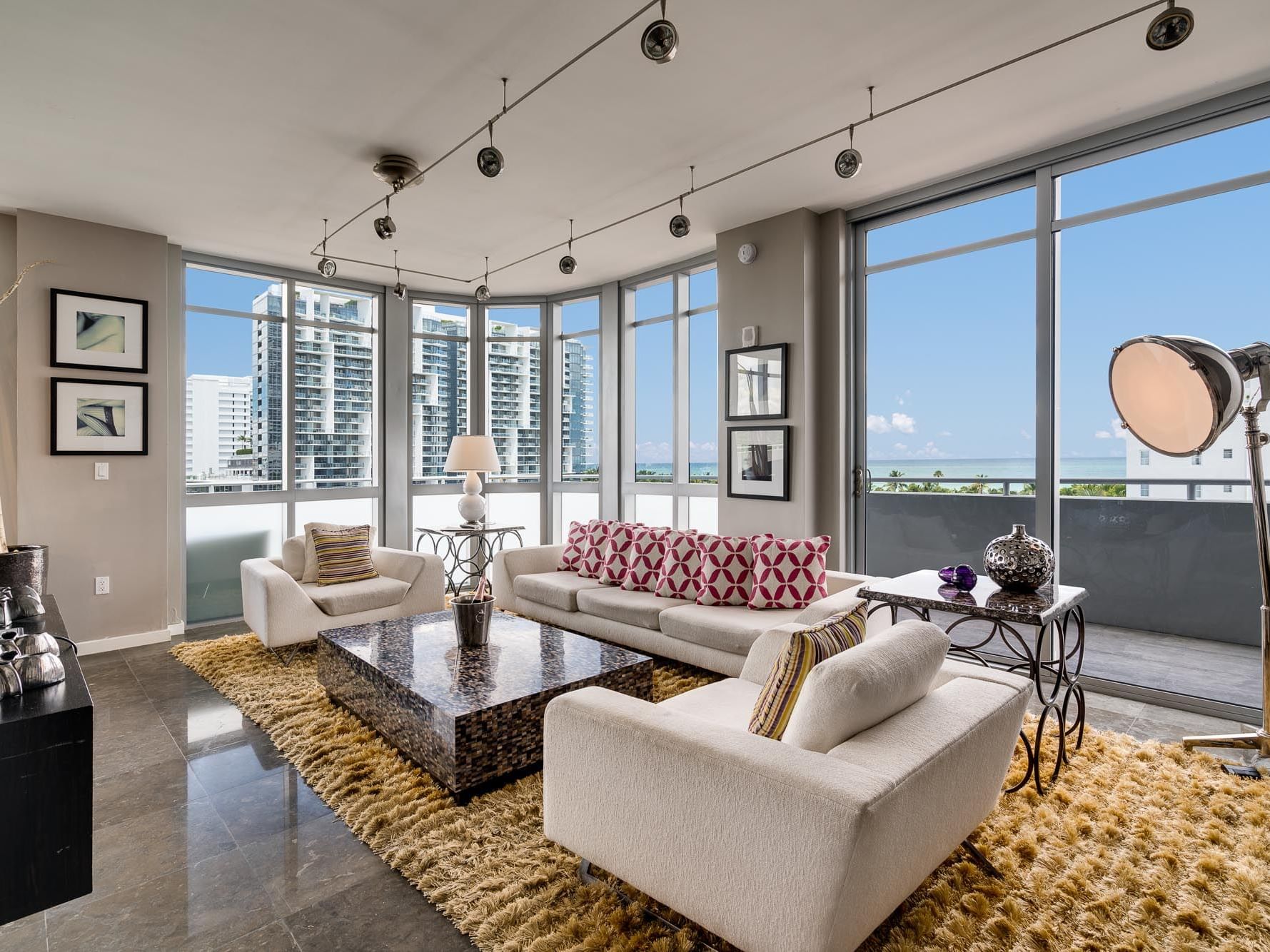 living room with sofas, large coffee table and floor to ceiling windows overlooking city