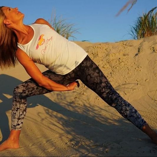 Karen from Pure Pony Yoga in Stone Harbor doing pose in front of sand dune