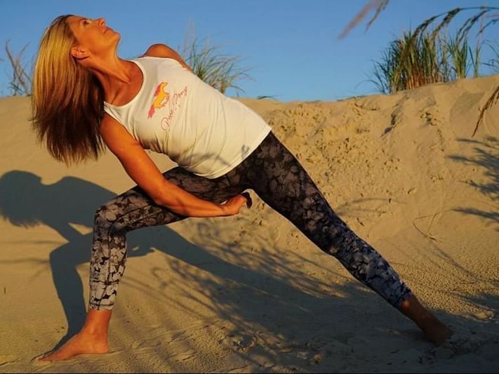 Karen from Pure Pony Yoga in Stone Harbor doing pose in front of sand dune