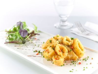 Gourmet fried calamari with salad on a white plate at York Hotel Singapore