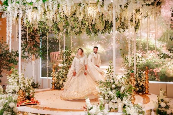 Couple under wedding mandap in The King Suite at Easthampstead Park in Berkshire