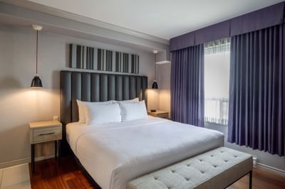 Jacuzzi Suite with large bed, hanging pendant lights and window at Sandman Hotel & Suites Winnipeg Airport