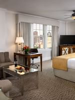 Corner King features Armchairs by a glass table under a ceiling fan at Warwick Melrose Dallas