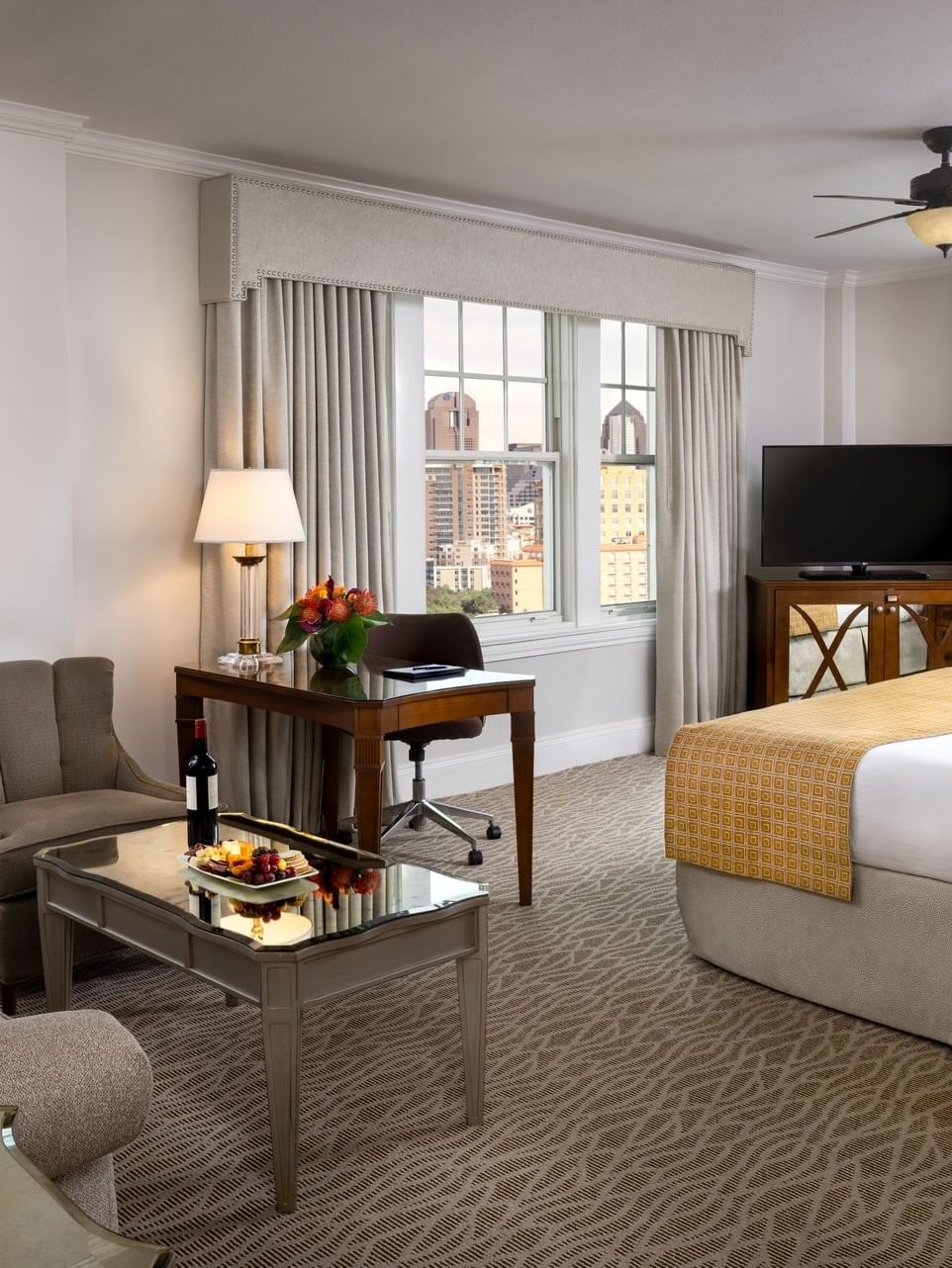Elegant Corner King room at Warwick Melrose, Dallas, featuring a cozy seating area and a large bed.