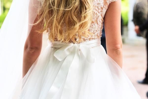 Bride wearing satin bow around her wedding dress