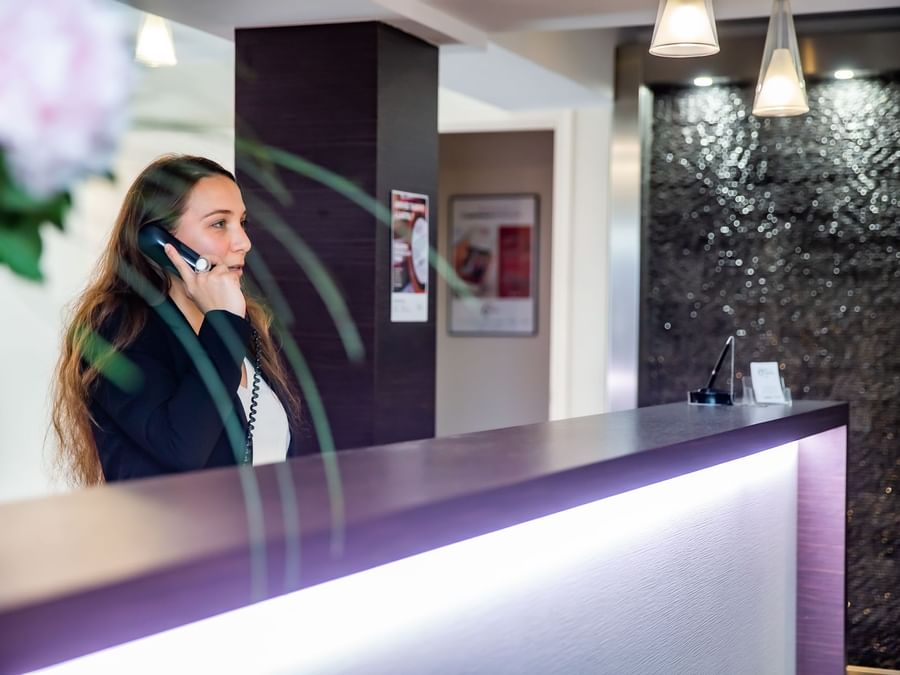 A receptionist at the reception desk in Hotel du Chateau