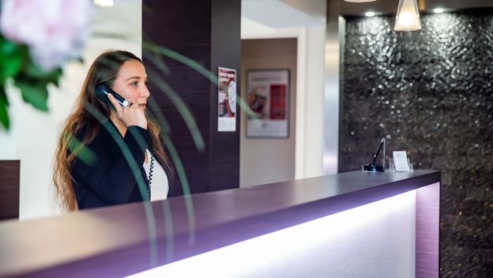 A receptionist at the reception desk in Hotel du Chateau