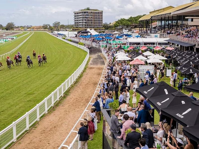 Crowded racecourse with horses on the track at Brisbane Racing Club near Sofitel Brisbane Central