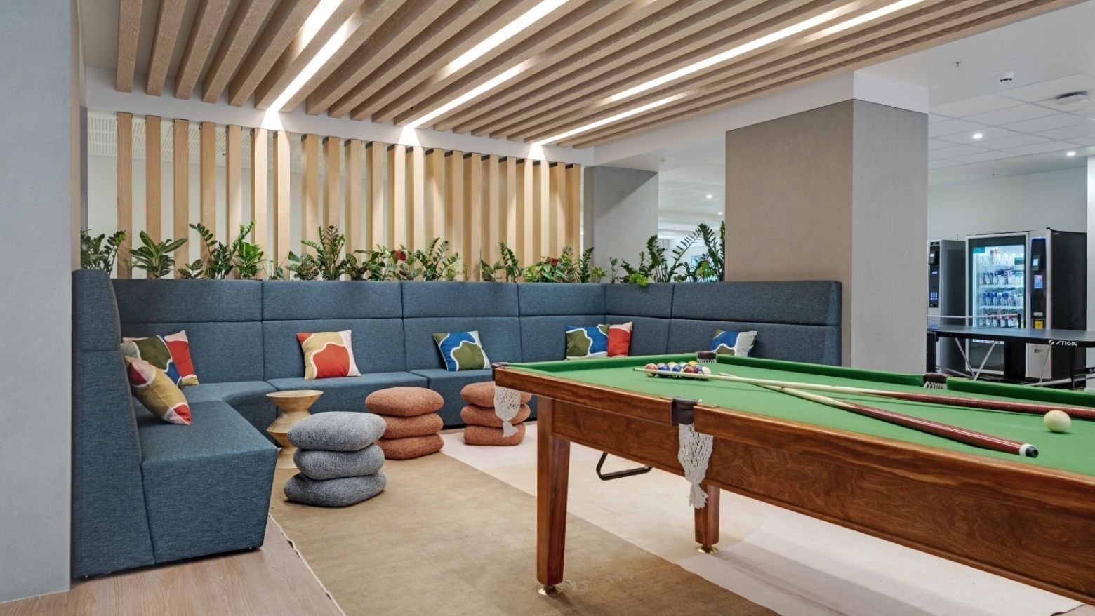 Modern recreation lounge with pool table, sectional seating, and wooden slatted ceiling at UniLodge Auckland Central