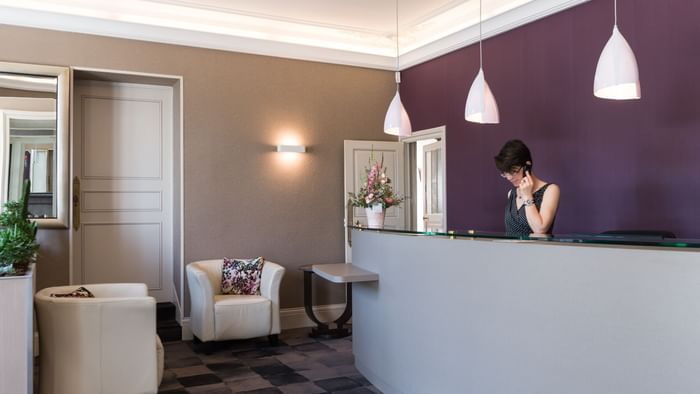 A receptionist at the reception desk in Hotel Normandie