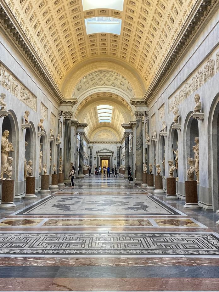 Interior of Vatican Museums with statues and crafted architecture near The Independent