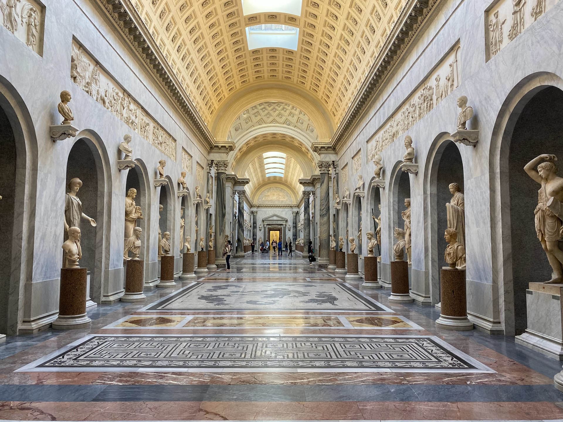 Interior of Vatican Museums with statues and crafted architecture near The Independent