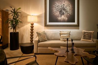 Living area with a light-colored sofa, a unique coffee table, and a large abstract painting at Singular Signature Residences