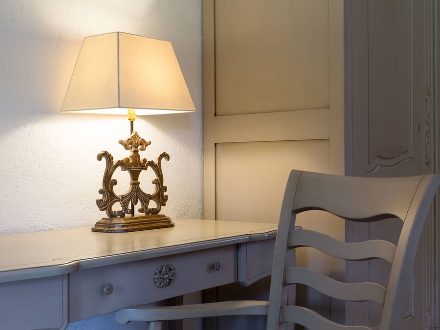 A table lamp and a chair in a room at L'Oree des Chenes