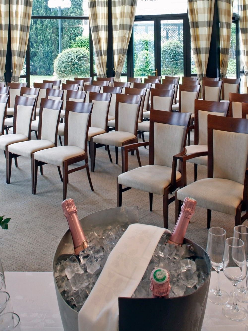 Chairs in Roseraie event room with flowers and champagne at Warwick Reine Astrid - Lyon.