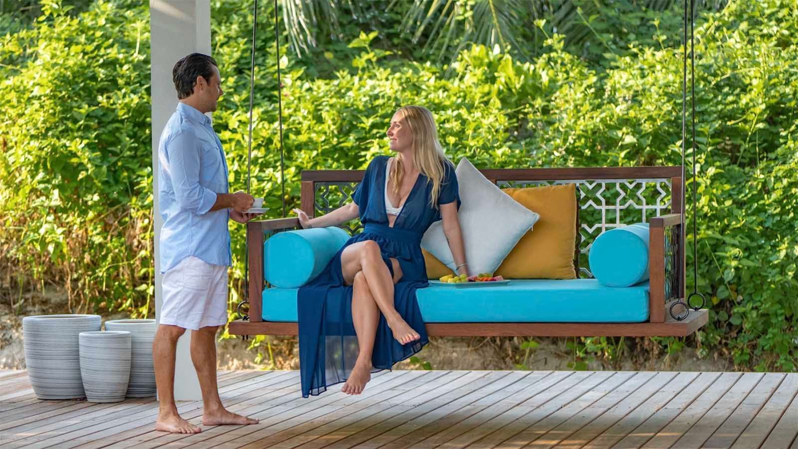 Couple relaxing on a swing at The Signature Collection