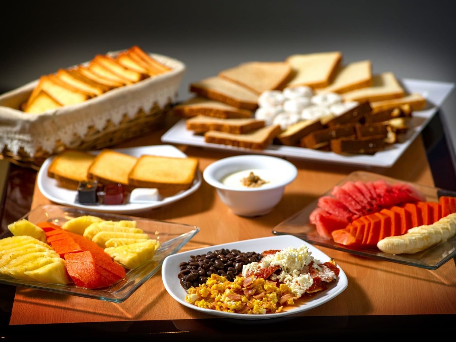 Pan, frutas, frijoles y salsas servidos en un restaurante, One Hotels