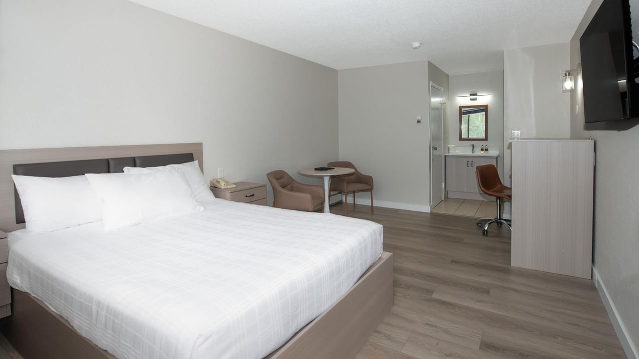 Guest room at Coast Red Deer Hotel with queen bed and seating area