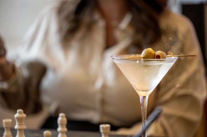 Chilled martini glass with olives served by a guest in Allerton Hotel Lobby Lounge at Warwick Allerton Chicago