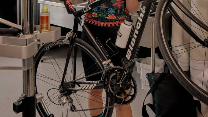Resident securing a black bicycle in the bike storage area at Swift Walk in Kensington