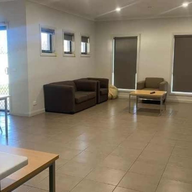 Spacious living room with couches, dining table, and TV at La Trobe University Regional Housing – Mildura.