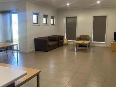 Spacious living room with couches, dining table, and TV at La Trobe University Regional Housing – Mildura.