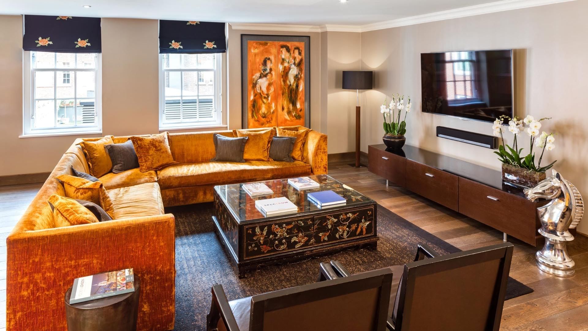 Luxurious living room in The Amber Suite at The May Fair Hotel London featuring a plush sofa, coffee table, and TV