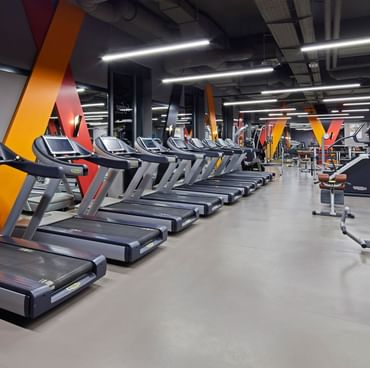 Treadmill machines lined up in BeFine Fitness Center at Titanic Chaussee Berlin