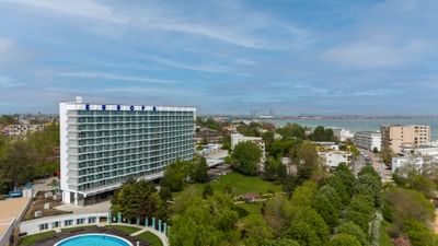 Exterior view of the Ana Hotels Europa Eforie Nord, featuring multiple glass balconies, and lush green landscaping