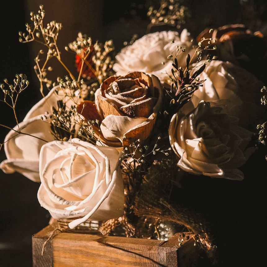 White rose bouquet on brown wooden table at The Stonebreaker Hotel