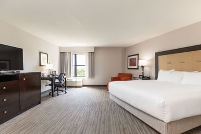 Premium King Room with a king bed, an orange armchair, a TV, and a wide work desk area at Branson Hillside Hotel