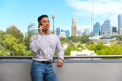 A man on a call on the balcony at Nesuto Hotels
